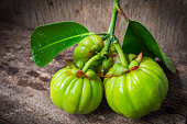 Still life with fresh garcinia cambogia on wooden background (Th