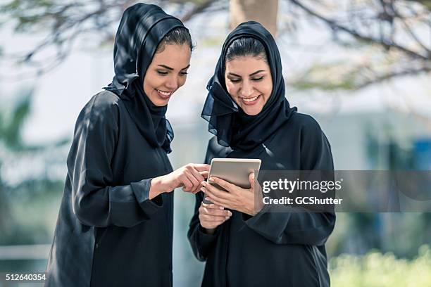 freizeit tag im park mit digitaltablett - emirati at work stock-fotos und bilder
