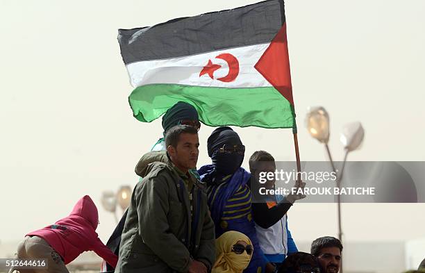 Sahrawis hold a Polisario Front's flag during a ceremony to mark 40 years after the Front proclaimed the Sahrawi Arab Democratic Republic in the...