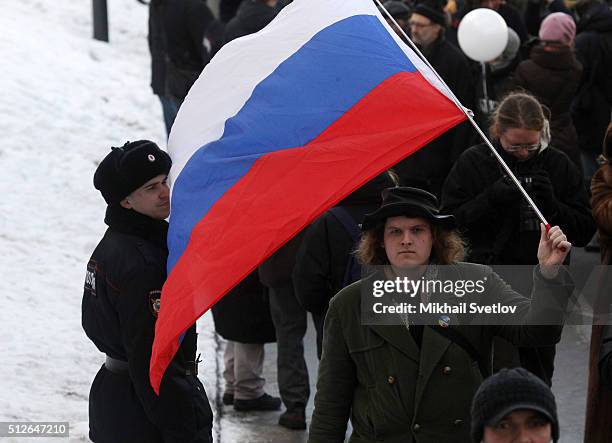 Man holds Russian flag during a mass march marking the one-year anniversary of the killing of opposition leader Boris Nemtsov on February 27, 2016 in...