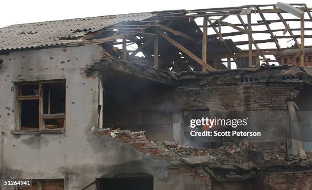 Friends and relatives visit the ruins of the destroyed school, where more than 350 people were killed during a hostage situation on September 5, 2004...