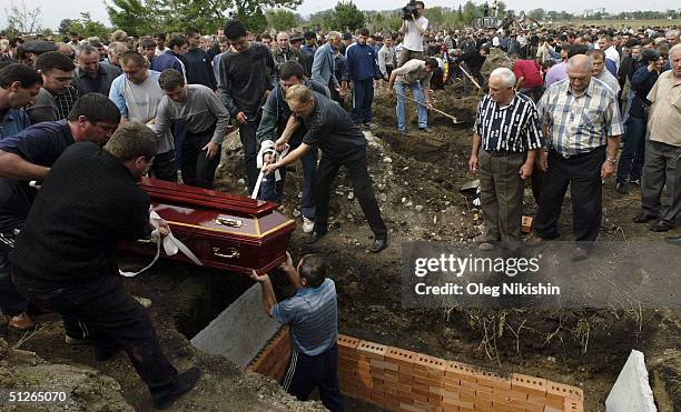 Friends and family bury the bodies of sisters Irina and Alina Tetova September 5, 2004 in Beslan, Russia. The girls were killed after Chechen...