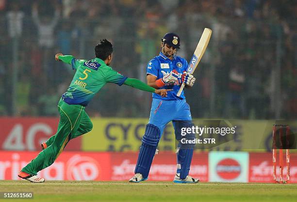 Pakistani cricketer Mohammad Amir celebrates after the dismissal of the Indian cricketer Suresh Raina during the match between India and Pakistan at...