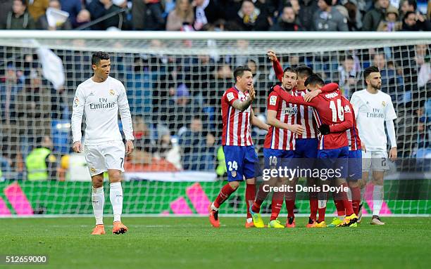 Cristiano Ronaldo of Real Madrid walks away from celebrating Atletico Madrid players after Atletico beat Real 1-0 in the La Liga match between Real...