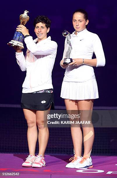Carla Suarez Navarro of Spain and Jelena Ostapenko of Latvia pose with their trophies at the end of their Qatar Open final tennis match on February...