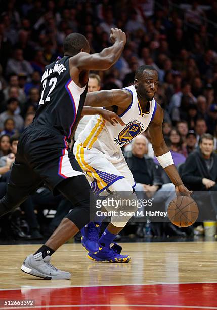 Draymond Green of the Golden State Warriors dribbles past Branden Dawson of the Los Angeles Clippers during the first half of a game at Staples...