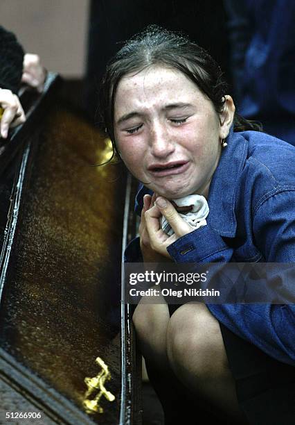 Family and friends of those killed in the school hostage crisis cry during a mass funeral in the rain September 6, 2004 in Beslan, southern Russia....