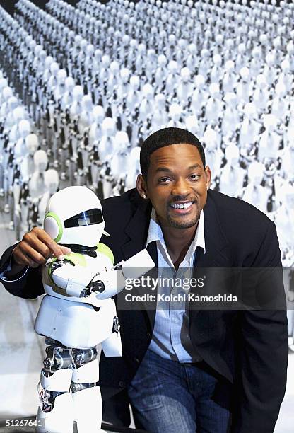 Actor Will Smith poses with humanoid robot PINO at a press conference to promote the film "I, Robot" September 7, 2004 in Tokyo, Japan.