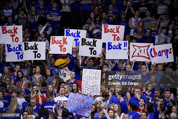 Fans and the Kansas mascot hold up signs as the prepare to celebrate another Kansas Big 12 Conference championship at Allen Fieldhouse on February...