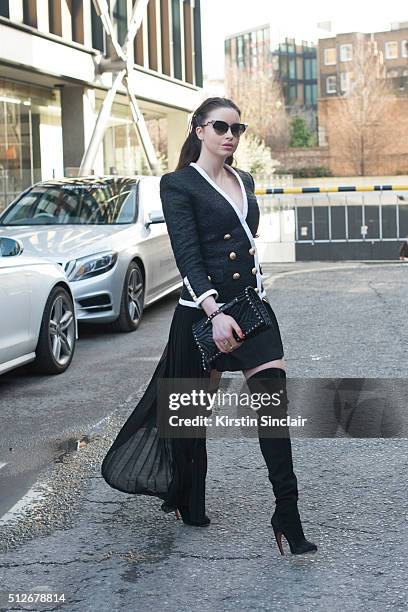 Model and Made in Chelsea star Emma Miller wears a Balmain jacket, Alexander McQueen skirt, Valentino bag, Alaia boots and Fendi sunglasses on day 4...