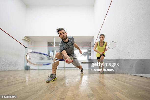below view of young man and woman playing squash. - racquetball bildbanksfoton och bilder