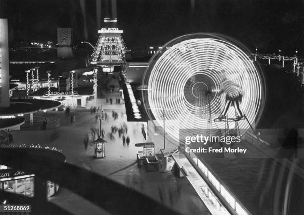 Illuminated rides at The Pleasure Beach in Blackpool, including a ferris wheel and the Big Dipper, 10th September 1955.