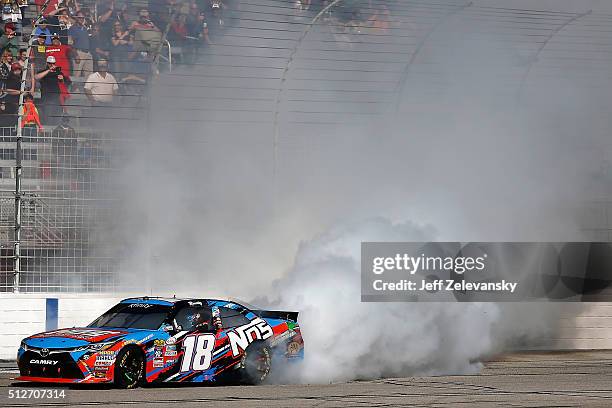 Kyle Busch, driver of the NOS Energy Drink Toyota, celebrates with a burnout after winning during the NASCAR XFINITY Series Heads Up Georgia 250 at...