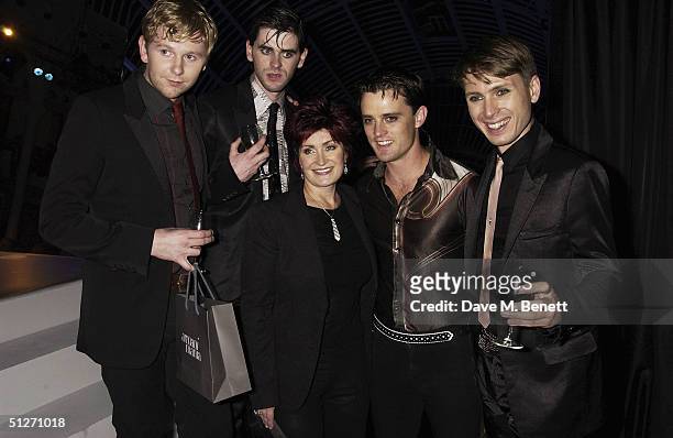 Franz Ferdinand's Alex Kapranos, Paul Thompson, Bob Hardy and Nick McCarthy pose with X Factor judge Sharon Osbourne in the pressroom at the "GQ Men...