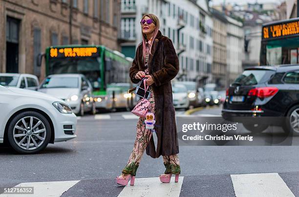 Anna dello Russo wearing Prada heels, Gucci suit, a pink Louis Vuitton bag, Fendi , Simonetta Ravizza fur coat, Glassing sunglasses seen outside...