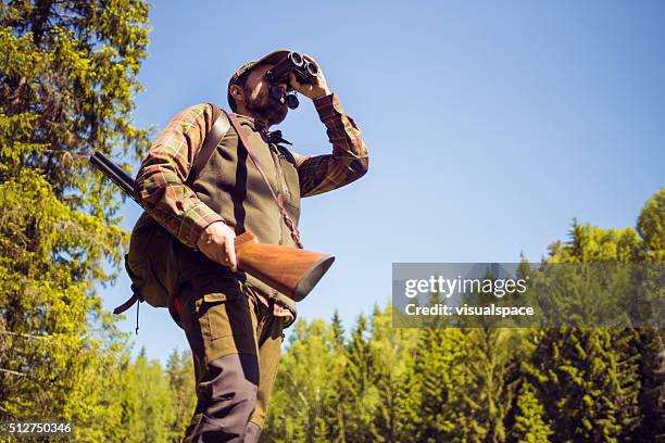 hunting man observing the field through field glasses - hagelgevär bildbanksfoton och bilder