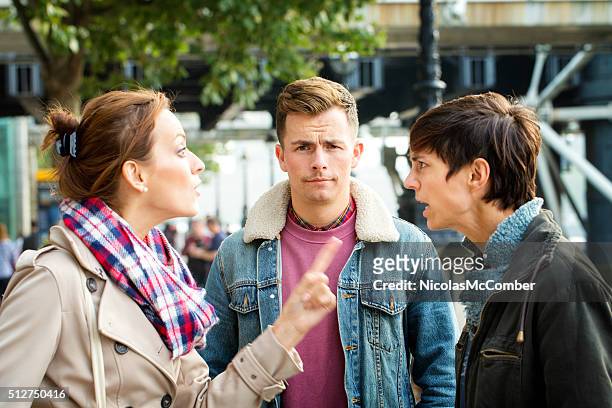 young man dismayed as his girlfriend argues with ex - fighting group stock pictures, royalty-free photos & images