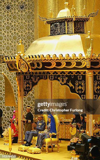 Bruneian Crown Prince Al-Muhtadee Billah Bolkiah and his bride, commoner Sarah Salleh, sit in the throne chamber at the Balai Singgahsana, Indera...