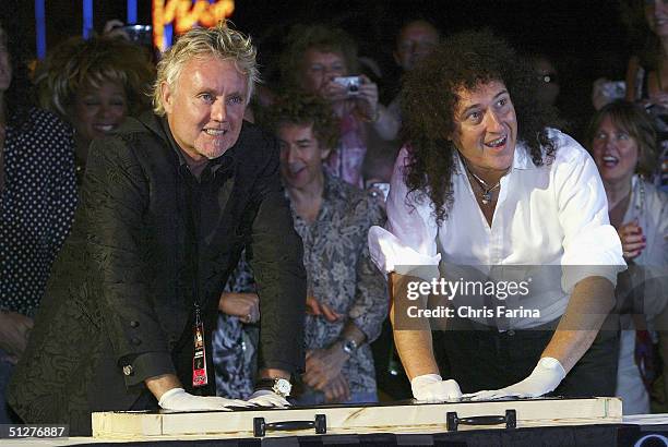 Drummer Roger Taylor and guitarist Brian May, founding members of the rock group Queen, put their hand prints into a special "In Memory Of" plaque,...