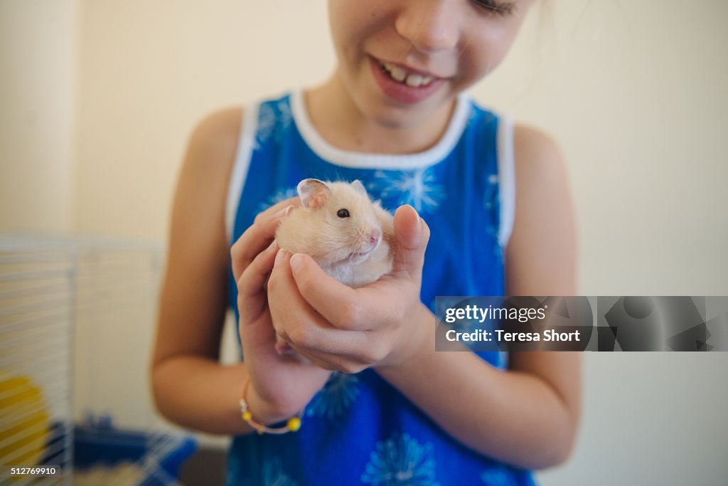 Girl is holding a pet hamster