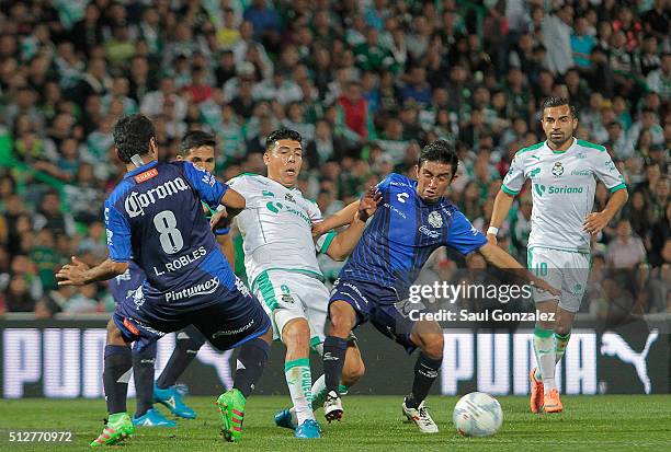 Luis Robles and Christian Bermudez of Puebla fight for the ball with Luis Mendoza of Santos Laguna during the 8th round match between Santos Laguna...