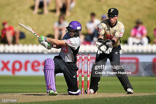 Henry Nicholls of South Island bats while Luke Ronchi of North Island looks on during the Island of Origin Twenty20 at Basin Reserve on February 28,...