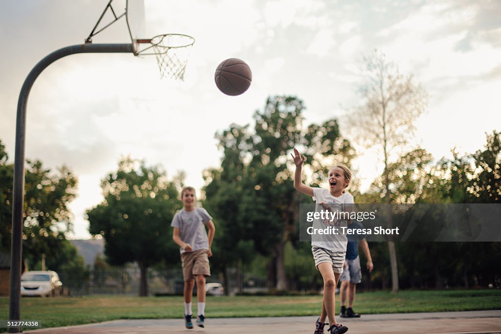 Family playing basketball togethe outdoors