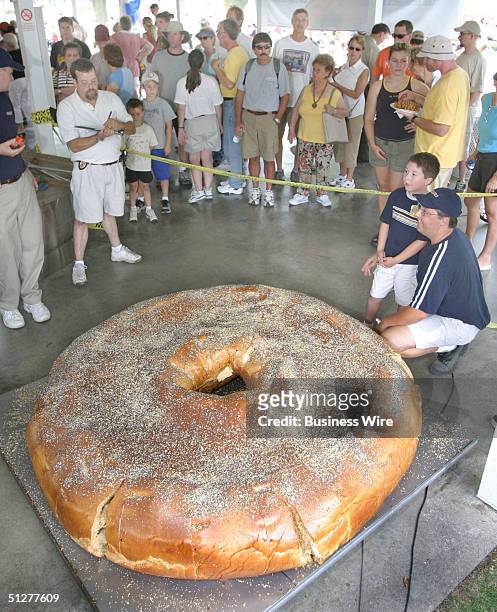 Fairgoers look on as Bruegger's Enterprises, Inc. Breaks the Guinness Book of World Records by baking an 868-pound bagel on August 27, 2004 at the...
