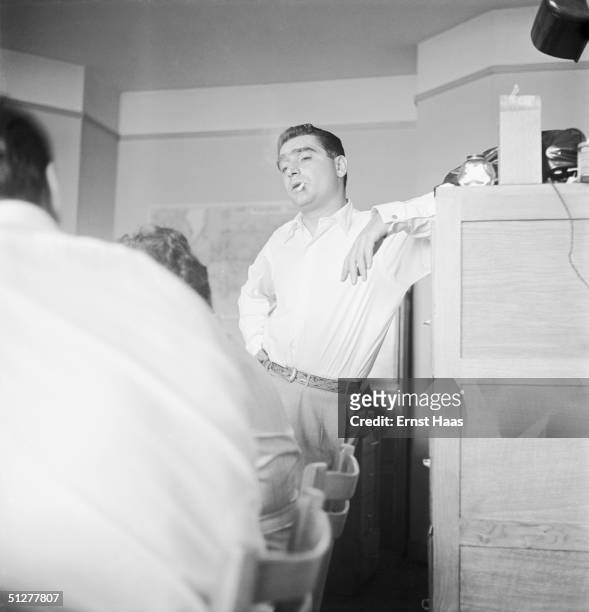 Hungarian-born photojournalist Robert Capa at a meeting of the Magnum photographic co-operative, Paris, circa 1947.
