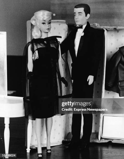Two children's dolls, Barbie and Ken, in formal wear, stand together in front of a toy closet, December 15, 1964.