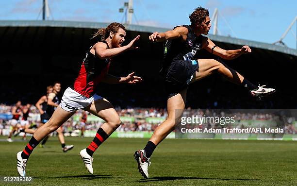 Charlie Curnow of the Blues kicks the ball ahead of Nick Kommer of the Bombers during the 2016 NAB Challenge match between the Carlton Blues and the...