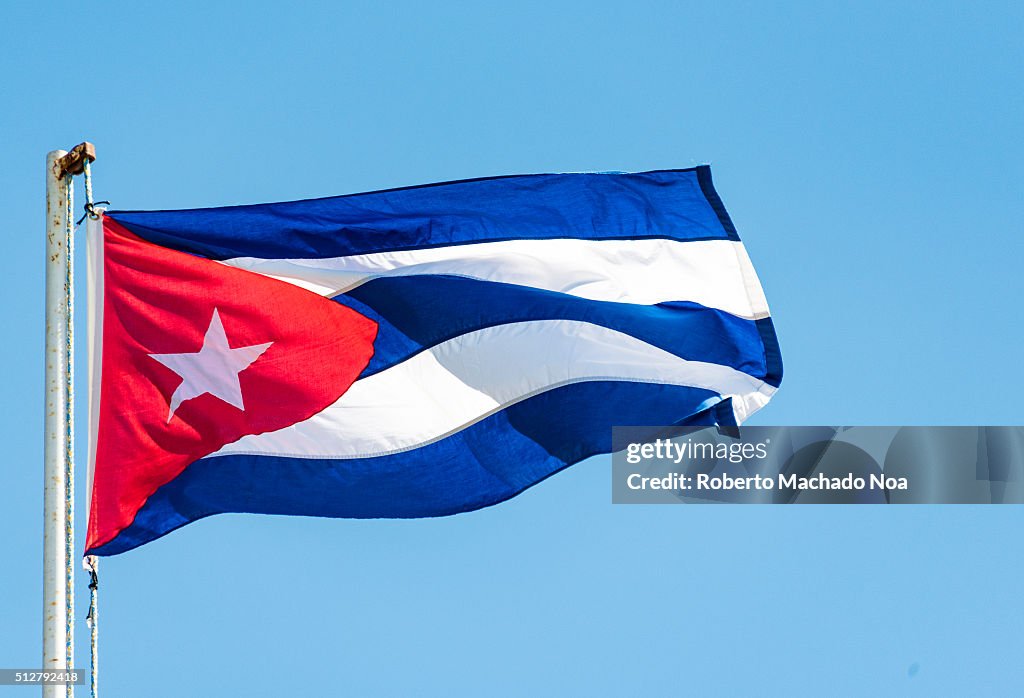 Colorful Cuban flag waiving high in the air, beautiful red,...