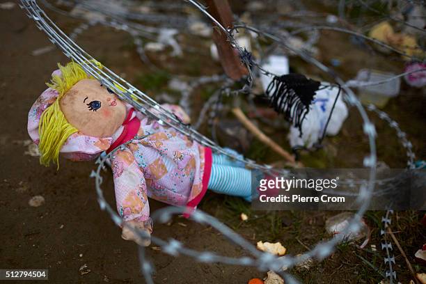 Lost doll hangs in barbed wires outside a transit camp which has become overcrowded as refugees continue to arrive from Athens and the Greek Islands...