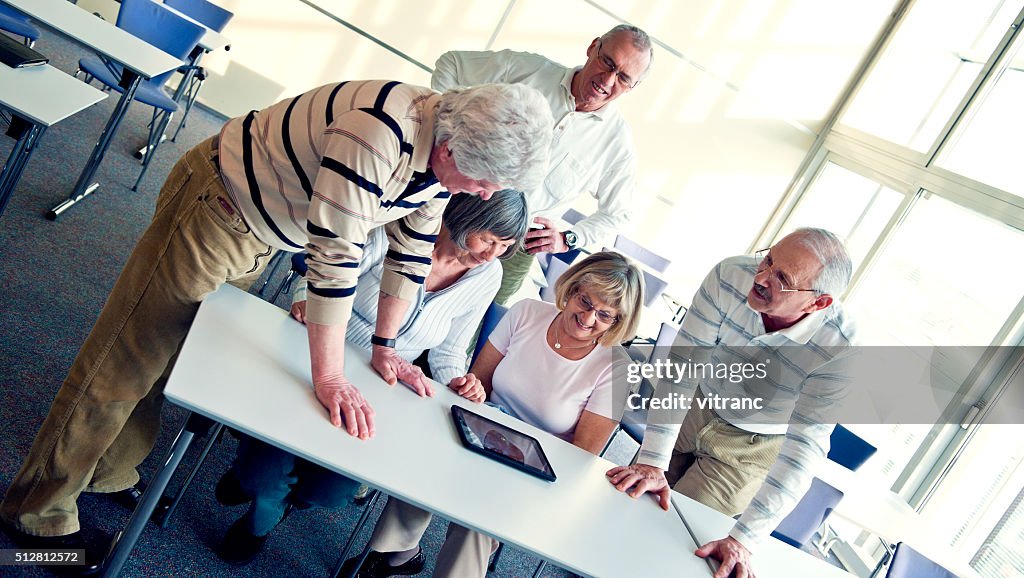 Grupo de senior adulto divirtiéndose con tableta digital
