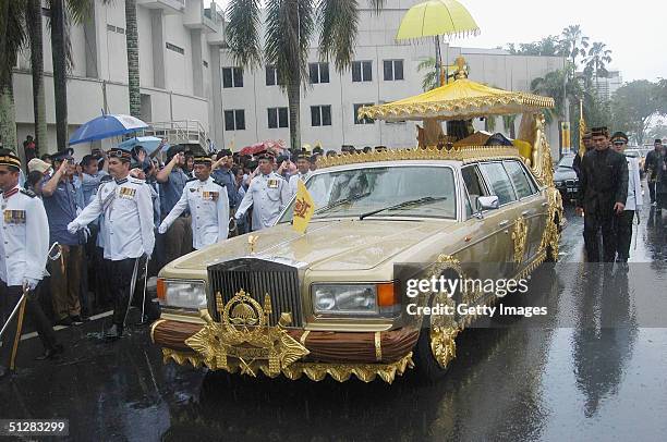 Bruneian Crown Prince Al-Muhtadee Billah Bolkiah and his bride, Princess Sarah, brave a monsoon downpour during their wedding procession in this...