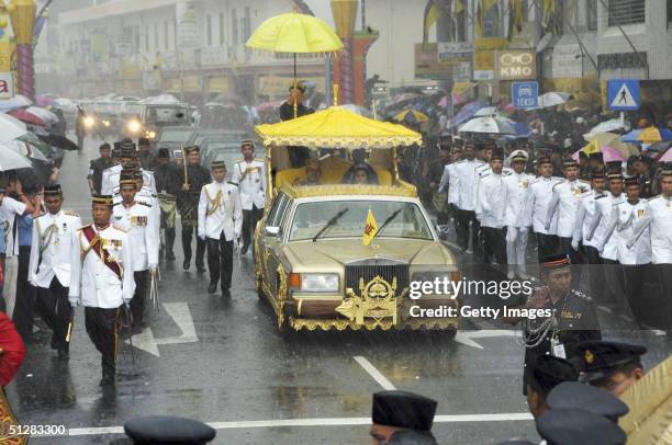 Bruneian Crown Prince Al-Muhtadee Billah Bolkiah and his bride, Princess Sarah, brave a monsoon downpour during their wedding procession in this...