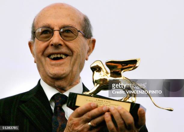 Portuguese director Manoel de Oliveira smiles as he poses with his Golden Lion received for his career prior to the premiere of his latest movie in...