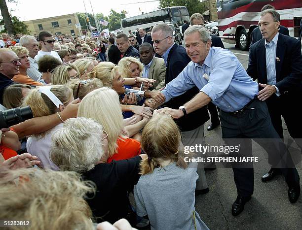 President George W. Bush shakes hands with supporters during an impromptu stop 10 September 2004 in Ironton, Ohio. Bush and Zell Miller are taking a...