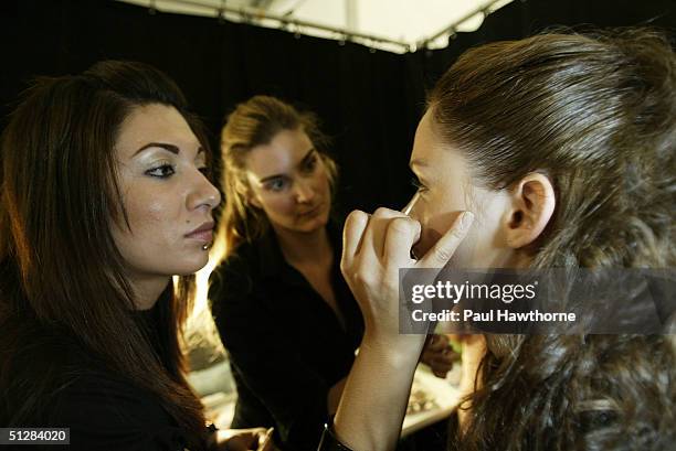 Felicia Cohen and Sarah Lucero , Stila Cosmetics make-up stylists, apply make-up to a model backstage during the Alice Roi Alice Roi Spring 2005...