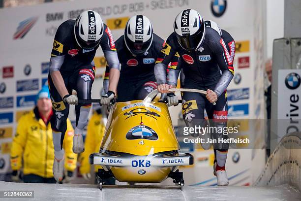 Germany's pilot Nico Walther and his pushers Marko Huebenbecker, Christian Poser and Eric Franke push their Bob off the start during the first run of...