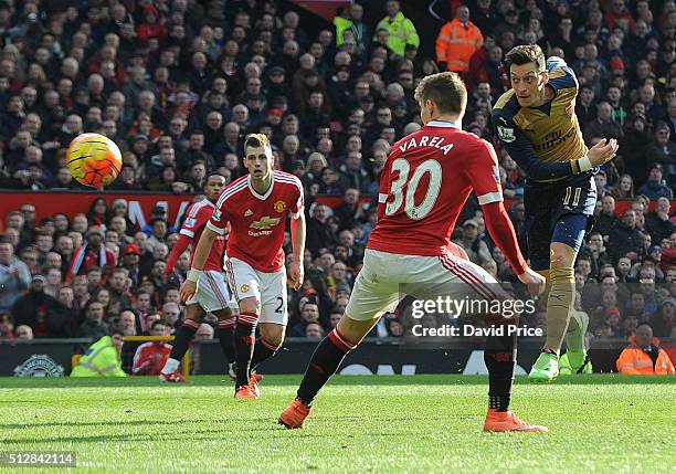 Mesut Ozil scores Arsenal's 2nd goal under pressure from Guillermo Varela of Man Utd during the Barclays Premier League match between Manchester...