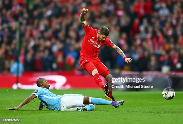 Fernandinho of Manchester City slides to tackle Alberto Moreno of Liverpool during the Capital One Cup Final match between Liverpool and Manchester...