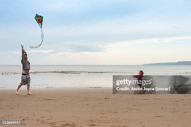 father and daughter flying kites - scarborough uk 個照片及圖片檔