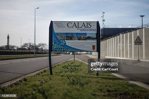 Welcome sign for Calais is pictured near a fence topped with razor wire protecting the harbour on February 28, 2016 in Calais, France. The French...