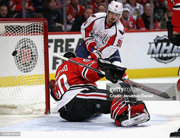 Marcus Johansson of the Washington Capitals slips the puck past Corey Crawford of the Chicago Blackhawks for a first period goal at the United Center...