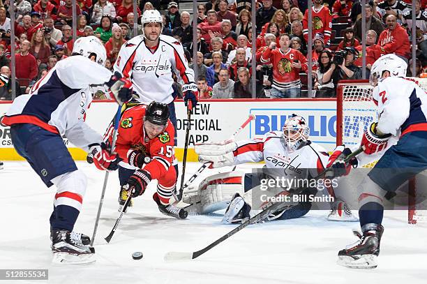 Artem Anisimov of the Chicago Blackhawks dives for the puck in front of Alex Ovechkin and goalie Braden Holtby of the Washington Capitals in the...