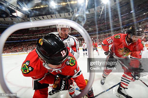 Brooks Orpik of the Washington Capitals chases the puck against Jonathan Toews and Andrew Ladd of the Chicago Blackhawks in the first period of the...