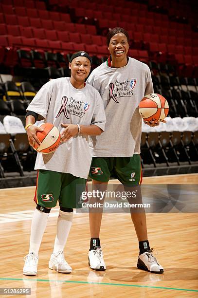 Betty Lennox and Janell Burse of the Seattle Storm wear special t-shirts celebrating WNBA Breast Health Awareness Day during pre-game warmups prior...