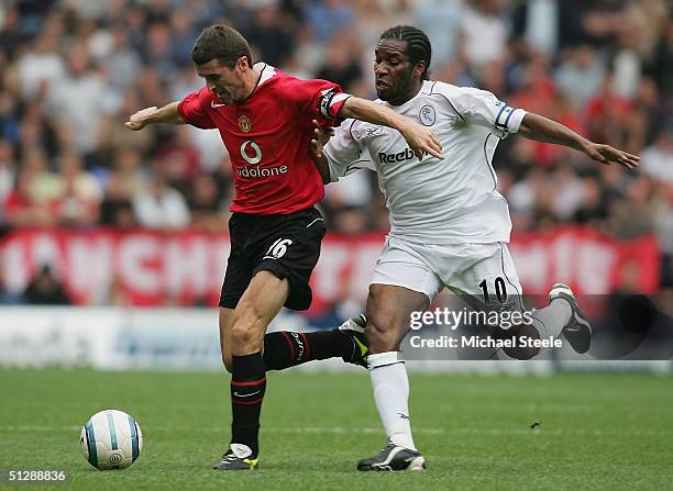 Jay Jay Okocha of Bolton clashes with Roy Keane of Man Utd during the Barclays Premiership match between Bolton Wanderers and Manchester United at...