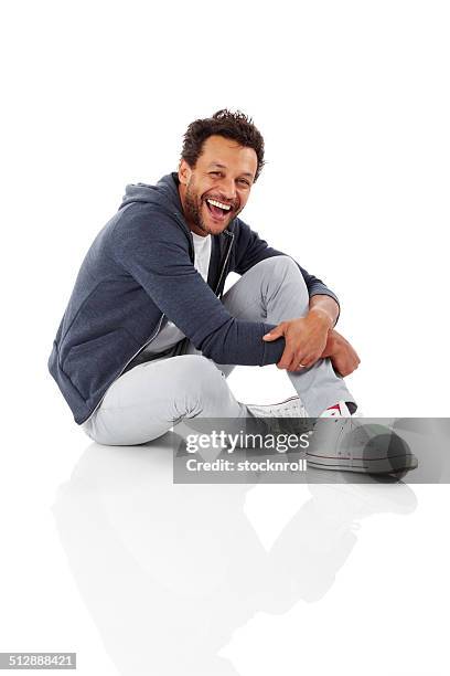 portrait of cheerful african man sitting on white - sitting on ground stock pictures, royalty-free photos & images
